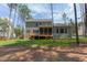 Exterior of home featuring a wood deck overlooking a backyard surrounded by tall pine trees at 205 Riverine Dr, Pittsboro, NC 27312