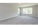 Spacious bedroom featuring carpet floors, two windows for natural light, and neutral walls, providing a calming atmosphere at 205 Riverine Dr, Pittsboro, NC 27312