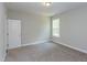 A bedroom with neutral walls, carpet, a window letting in natural light, and a white door at 205 Riverine Dr, Pittsboro, NC 27312