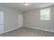 Bedroom with neutral walls, a white door, carpet, and a window overlooking the outdoors at 205 Riverine Dr, Pittsboro, NC 27312