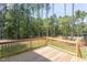 A wood deck overlooks a grassy area and a border of trees, providing a private outdoor space at 205 Riverine Dr, Pittsboro, NC 27312