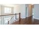 Open hallway featuring hardwood floors, a staircase with white railing, and a large chandelier, providing an open, welcoming feel at 205 Riverine Dr, Pittsboro, NC 27312