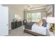 Bedroom featuring a canopy bed, stylish decor, carpet floors, and a large window with views of the backyard deck at 205 Riverine Dr, Pittsboro, NC 27312