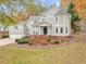 Charming two-story home with gray siding, a well-manicured lawn, mature trees, and an attached three-car garage at 206 Arbor Dr, Elon, NC 27244