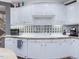 A kitchen counter with white cabinets, gold hardware, and a backsplash made of glass blocks at 206 Arbor Dr, Elon, NC 27244