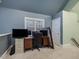 A carpeted home office space with large windows, neutral walls and storage at 206 Arbor Dr, Elon, NC 27244
