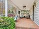 Covered patio with brick floor, seating and view of backyard at 206 Arbor Dr, Elon, NC 27244