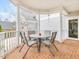Covered back patio with brick flooring, a table with 4 chairs and features white railings and columns at 206 Arbor Dr, Elon, NC 27244
