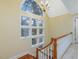 Staircase with large window and chandelier, offering natural light and an elegant design with wooden stairs at 206 Arbor Dr, Elon, NC 27244