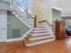 Beautiful staircase featuring hardwood treads, white risers, and a natural wood handrail, bathed in natural light at 206 Arbor Dr, Elon, NC 27244