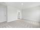 Light-filled bedroom featuring neutral walls and soft carpet with a view to a bathroom at 21 Artesa Ct, Fuquay Varina, NC 27526