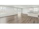 Spacious living room featuring hardwood floors, lots of natural light, and an island-style kitchen in the background at 21 Artesa Ct, Fuquay Varina, NC 27526