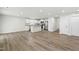 Bright, open-concept living space with hardwood floors and a modern kitchen featuring stainless steel appliances at 21 Artesa Ct, Fuquay Varina, NC 27526