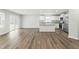 Open concept living space with kitchen, dining, and living areas, and wood-look floors at 21 Artesa Ct, Fuquay Varina, NC 27526