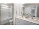 Bathroom featuring double vanity sinks with white cabinets and a shower-tub combo at 2156 Monk Dr, Haw River, NC 27258