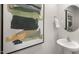 Stylish powder room with modern fixtures, artistic painting, and round mirror detail at 2156 Monk Dr, Haw River, NC 27258