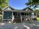 Rear exterior featuring a covered porch, white railings, and steps leading to the patio at 223 E Nash St, Spring Hope, NC 27882