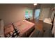 Bedroom with hardwood floors, natural light, neutral paint, floral quilt, and checkered pillows at 223 E Nash St, Spring Hope, NC 27882