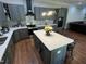 Stylish kitchen boasts stainless appliances, gray cabinets, a center island, and modern backsplash at 223 E Nash St, Spring Hope, NC 27882