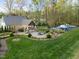 Beautifully landscaped backyard with an outdoor kitchen, fire pit, pool and lush green grass at 2259 Helena Moriah Rd, Timberlake, NC 27583