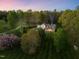 Expansive aerial view showcasing a picturesque home, lush landscaping, and a serene treed setting at 2259 Helena Moriah Rd, Timberlake, NC 27583