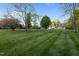 Beautifully landscaped front yard with mature trees, lush green grass and a glimpse of the house at 2259 Helena Moriah Rd, Timberlake, NC 27583