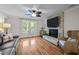 Bright living room with a stone fireplace, hardwood floors, and a large window at 2259 Helena Moriah Rd, Timberlake, NC 27583