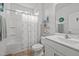 White bathroom with vanity, shower-tub combo, and decorative ocean-themed elements at 252 Tyree Trl, Burlington, NC 27215