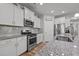 Modern kitchen featuring stainless steel appliances, granite countertops, and white cabinetry at 252 Tyree Trl, Burlington, NC 27215