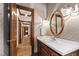 Bathroom with wallpaper, oval mirror, and a hallway view at 2720 Townedge Ct, Raleigh, NC 27612