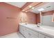 Bathroom featuring double sinks with white cabinets, pink walls, and large mirror at 2720 Townedge Ct, Raleigh, NC 27612