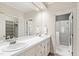 Bathroom with double sinks, large mirror, and tiled shower at 2720 Townedge Ct, Raleigh, NC 27612