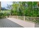 A large deck with decorative railings offers stunning views of the surrounding greenery at 2720 Townedge Ct, Raleigh, NC 27612