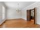 Dining room featuring hardwood floors, large windows, and elegant chandelier at 2720 Townedge Ct, Raleigh, NC 27612