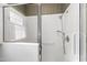 Shower stall featuring white tiling, glass doors, and updated fixtures in a beautifully tiled bathroom at 2720 Townedge Ct, Raleigh, NC 27612