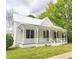 Charming exterior view of a two-story home featuring a welcoming front porch and well-maintained yard at 305 N Webb St, Selma, NC 27576