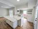 Modern kitchen with a large center island, white cabinets, gold accents, and stainless steel appliances at 305 N Webb St, Selma, NC 27576