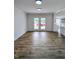 Spacious open living room with wood flooring and ample natural light from the glass paneled exterior doors at 305 N Webb St, Selma, NC 27576