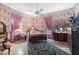 Cozy bedroom with floral wallpaper, four poster bed and ceiling fan at 308 S Pearl St, Rocky Mount, NC 27804