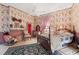 Bedroom with floral wallpaper, four poster bed, and natural light at 308 S Pearl St, Rocky Mount, NC 27804