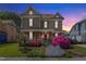 Charming two-story home with a covered front porch and beautiful landscaping at dusk at 308 S Pearl St, Rocky Mount, NC 27804