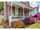 Charming porch with a swing, seating, decorative railings and vibrant flowering shrubbery at 308 S Pearl St, Rocky Mount, NC 27804