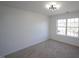 Sunlit bedroom featuring neutral walls and carpet, a stylish ceiling light, and a large window for ample natural light at 3244 Marcony Way, Raleigh, NC 27610