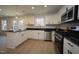 Bright kitchen features white cabinets, stainless steel appliances, and black countertops at 3244 Marcony Way, Raleigh, NC 27610