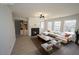 Bright living room features a fireplace, modern light fixture, and ample natural light from the many surrounding windows at 3244 Marcony Way, Raleigh, NC 27610