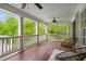 Spacious back porch featuring a wood floor, multiple ceiling fans, and an outdoor seating area at 3332 Cheswick Dr, Raleigh, NC 27609