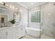 Elegant bathroom features a soaking tub, a walk-in shower, and a double vanity with white cabinets at 3332 Cheswick Dr, Raleigh, NC 27609