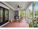 Inviting covered porch with a brick floor, ceiling fan, screened-in porch, and an outdoor dining set at 3332 Cheswick Dr, Raleigh, NC 27609