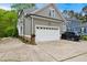 Exterior view of a home featuring gray siding, a two-car garage, a driveway, and manicured landscaping at 3332 Cheswick Dr, Raleigh, NC 27609