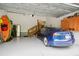 Attached garage with a modern electric car, kayaks, storage cabinets, and stairs leading into the house at 3332 Cheswick Dr, Raleigh, NC 27609